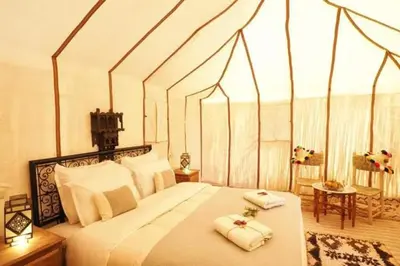 a bedroom with a large bed with two towels on it at Zagora Luxury Camp in Zagora