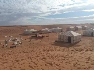 a group of tents in the middle of a desert at Zagora Luxury Camp in Zagora