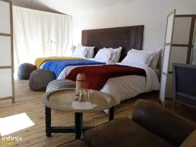 a hotel room with two beds and a table at Zagora Luxury Camp in Zagora