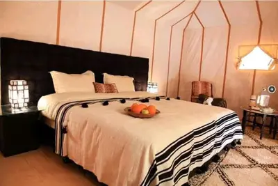 a bedroom with a bed with a bowl of fruit on it at Zagora Luxury Camp in Zagora
