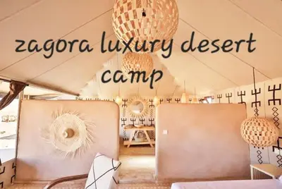 a room with a tent with chandeliers in it at Zagora Luxury Camp in Zagora