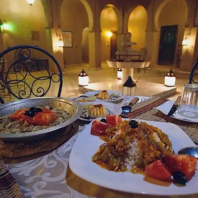 a table with plates of food on top of it at Riad Dar Ouzine in Merzouga