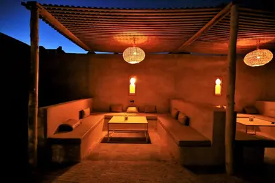 a room with couches and a table and lights at Riad Dar Ouzine in Merzouga