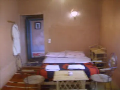 a room with a bed and a table and chairs at auberge restau tombouctou in Aït Ben Haddou