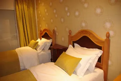 two beds in a hotel room with white pillows at Résidence Ifrane Palace in Ifrane