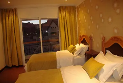 a hotel room with two beds and a balcony at Résidence Ifrane Palace in Ifrane