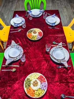 a table with plates of food on a red table cloth at Café restaurante shelter calm life in Bou Dib