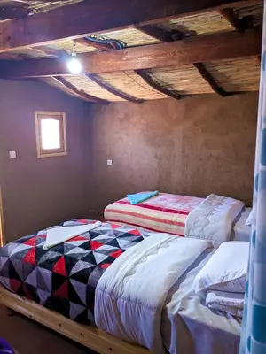 two twin beds in a room with a ceiling at Café restaurante shelter calm life in Bou Dib