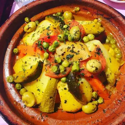 a bowl of food with vegetables and peas at Café restaurante shelter calm life in Bou Dib
