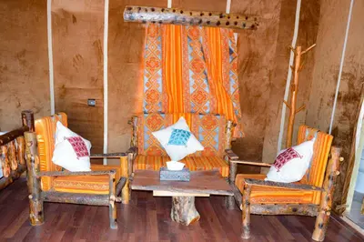 a room with two chairs and a table with pillows at Relaxing Desert Camp in Merzouga