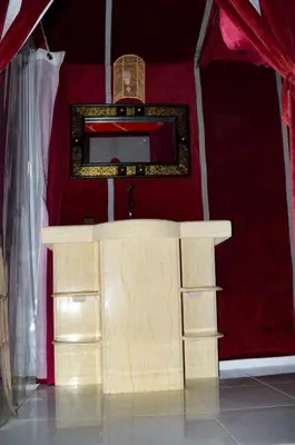 a wooden altar in a red room with a mirror at Relaxing Desert Camp in Merzouga