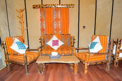 two chairs and a table with pillows on them at Relaxing Desert Camp in Merzouga