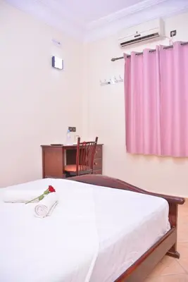 a bedroom with a bed with a pink curtain at Hôtel Elfekri in Er Rachidia