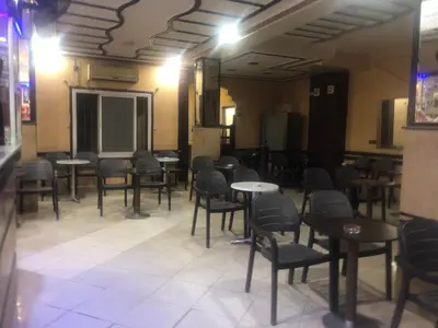 a room with tables and chairs in a restaurant at Hôtel Elfekri in Er Rachidia