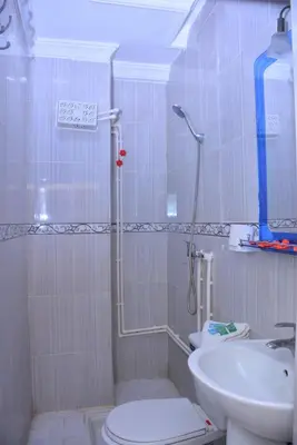 a bathroom with a shower and a toilet and a sink at Hôtel Elfekri in Er Rachidia
