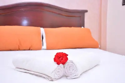 a bed with towels and a red rose on it at Hôtel Elfekri in Er Rachidia