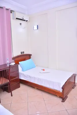 a bedroom with a bed and a table and a chair at Hôtel Elfekri in Er Rachidia