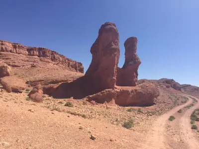 a rock formation in the desert with a dirt road at Casbah d'hôte La Jeanne Tourisme Ecologique in Boumalne