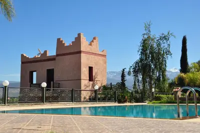 a villa with a swimming pool in front of a building at Le Beau Site Ourika in Aghmat