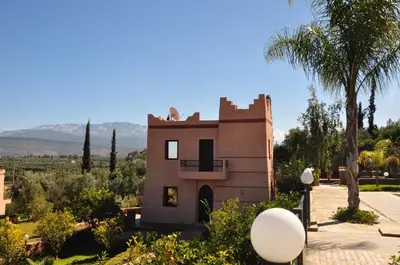 a house in the middle of a desert with palm trees at Le Beau Site Ourika in Aghmat