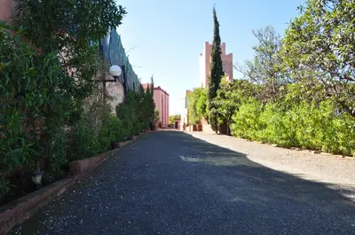 an empty road in a city with buildings and trees at Le Beau Site Ourika in Aghmat