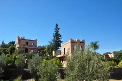 a house in the middle of a garden with trees at Le Beau Site Ourika in Aghmat