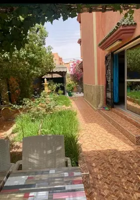 two chairs sitting on a brick walkway next to a building at Villa Eden in Ouarzazate