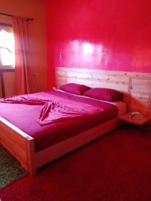 a bedroom with a large bed with a red wall at Villa Eden in Ouarzazate