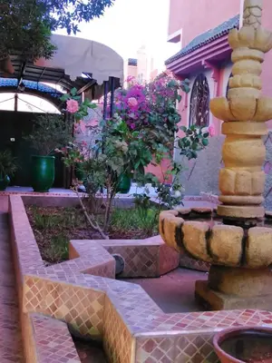 a garden with a fountain in front of a house at Villa Eden in Ouarzazate