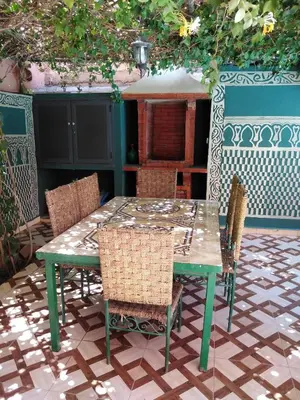 a green table and chairs on a patio at Villa Eden in Ouarzazate