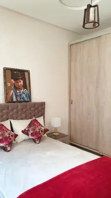 a bedroom with a large bed with a red blanket at Maison GHITA in Azrou