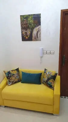 a yellow couch in a room with a painting on the wall at Maison GHITA in Azrou