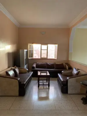 a living room with leather couches and a window at Ferme fes in Fès