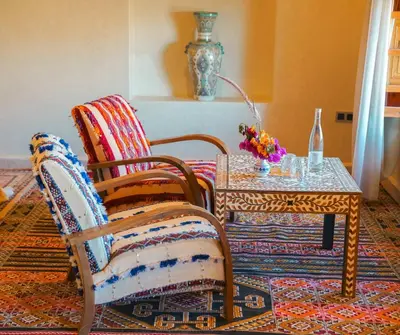 a room with two chairs and a table and a vase at Kasbah Hnini in Igdourane