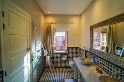 a bathroom with a sink and a toilet and a mirror at Kasbah Hnini in Igdourane