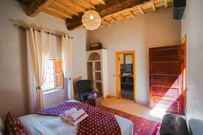 a bedroom with a bed in a room with a window at Kasbah Hnini in Igdourane