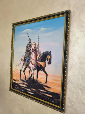 a painting of two men riding horses on a beach at Darkoum votre appartement in Fès