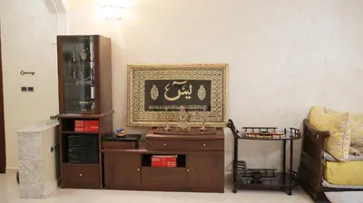 a living room with a table and a picture on the wall at Darkoum votre appartement in Fès