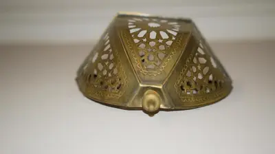 a gold object is sitting on a white surface at Darkoum votre appartement in Fès