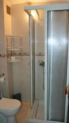 a bathroom with a toilet and a glass shower at Darkoum votre appartement in Fès