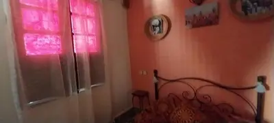 a bedroom with a bed and a window with pink light at Riad lala zakia in Moulay Idriss Zerhoun