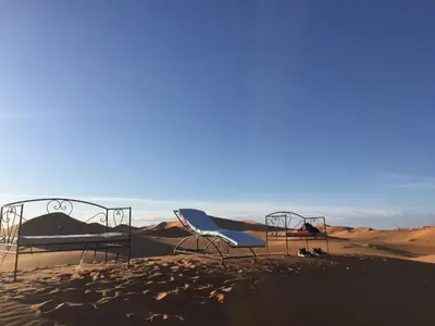 two beds in the sand in the desert at Moda Camp merzouga tours Quad Sunboarding ATV in Merzouga