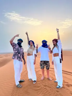 a group of women standing in the desert at Moda Camp merzouga tours Quad Sunboarding ATV in Merzouga
