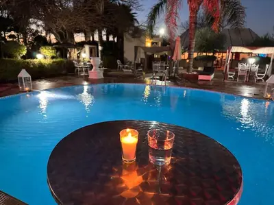 a candle sitting on a table next to a swimming pool at Weedan Hôtel&Spa Marrakech in Oulad Snaguia
