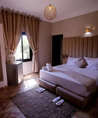 a bedroom with a large bed and a large window at Weedan Hôtel&Spa Marrakech in Oulad Snaguia