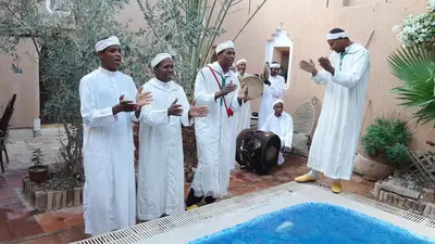 a group of men standing next to a swimming pool at Dar Amazir in Agdz