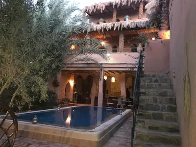 a house with a swimming pool in front of a building at Dar Amazir in Agdz