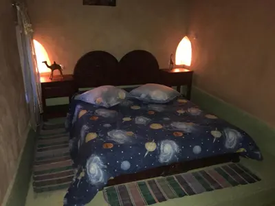 a bedroom with a bed with a moon and stars blanket at Dar Amazir in Agdz