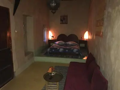 a bedroom with a bed and a couch in it at Dar Amazir in Agdz