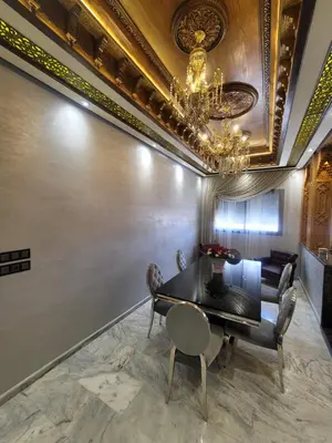 a dining room with a table and chairs and a chandelier at ZR Comfort Delux in Fès